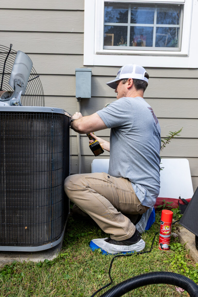 Technician servicing an outdoor air conditioner