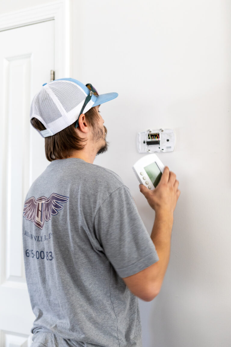 Heavenly Air technician programming a home thermostat